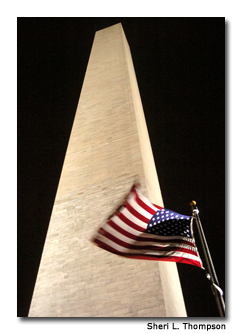 As the stone obelisk towers above, the flags at the base of the Washington Monument snap to attention in the wind.