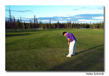 Teeing off around midnight, a golfer casts a long shadow.