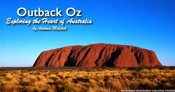 Ayers Rock looms over the Australian outback.