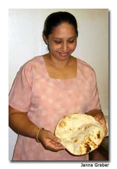 At Zaffron, an employee shows off fresh naan, a soft, pita-like bread that accompanies many Indian meals.