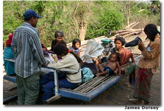 A mix of passengers board the train, paying their passage with barter. 