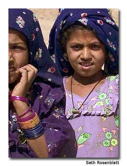 Ravina and Moru, two young desert villagers, hesitantly approach the camel safari.