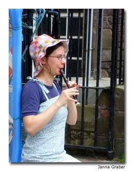 A street entertainer plays her flute outside Edinburgh Castle.