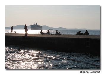 A seaside symphony is created by Nikola Basic’s landscape art on the promenade at sunset.