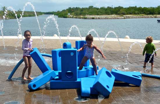    Children love cooling off in the fountains at Camana Bay.