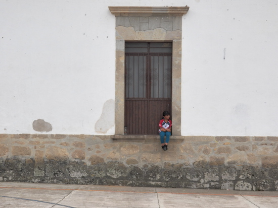 A child sitting in one of the stone windowsills in San Sebastian, Mexico. Photo by Cynthia Pulido  