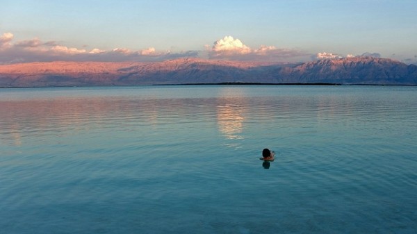 A person pauses to look at the sunset over Jordan.