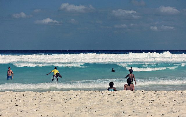 Children play on the beach in Cancun, Mexico. Flickr/Tom Hart