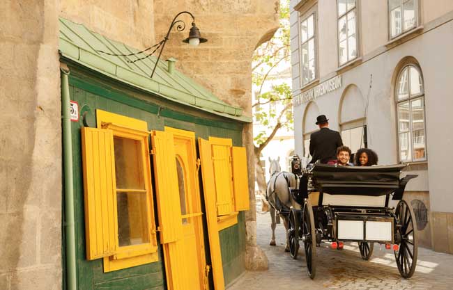 Riding through the old town in a traditional horse-drawn carriage. ©WienTourismus / Peter Rigaud