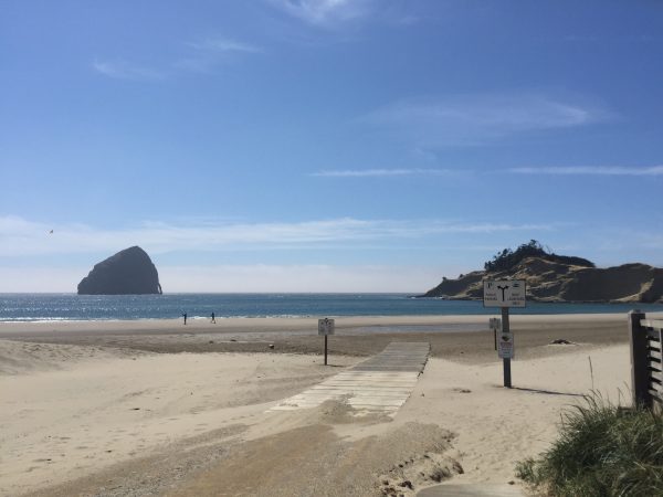 Haystack Rock sticks up out of the water in the distance in Pacific City, Oregon.