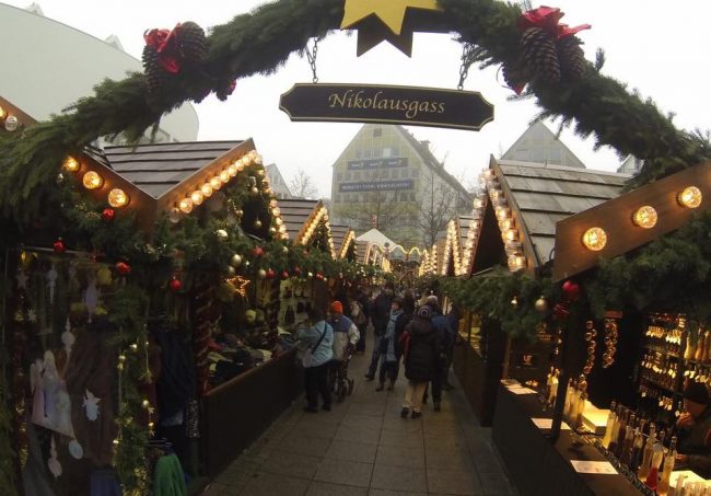 The large Christmas market in Ulm, Germany features little "streets" of wooden stalls selling food, handmade craft and Christmas items. Photo by Janna Graber