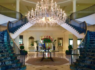 Classic Southern "Open Arm" staircase showcases crystal chandelier in the marble lobby. Photo by Claudia Carbone