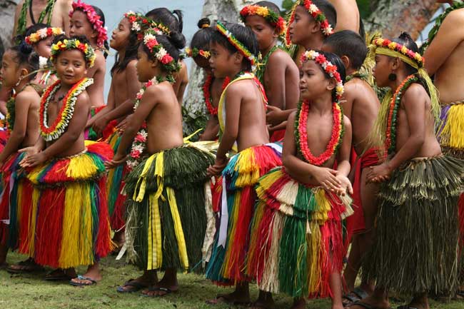 Young girls sing during Yap Day dressed in traditional grass skirts and woven garlands called "nunuws."  Photo by Joyce McClure