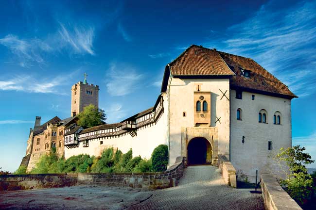 Wartburg Castle, where Luther spent 10 months hiding from potential assassins after the pope declared him a heretic, stands on a mountaintop high above Eisenach. (Photo credit: Anna-Lena Thamm — Thüringer Tourismus GmbH)