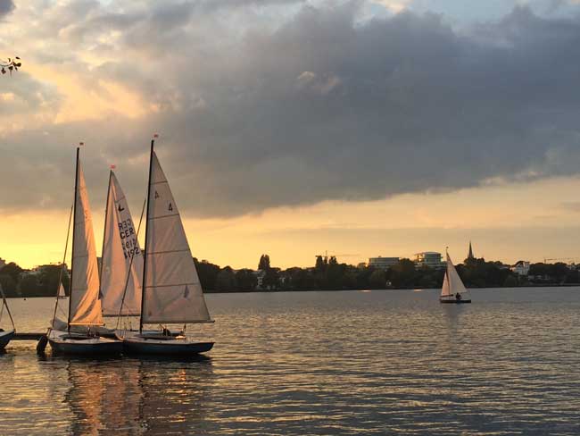 Sailboats at sunset on Alster Lake in Hamburg. Photo by Janna Graber