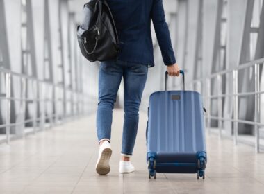 Man With Bag And Suitcase Walking In Airport Terminal. Photo by Prostock-Studio, iStock