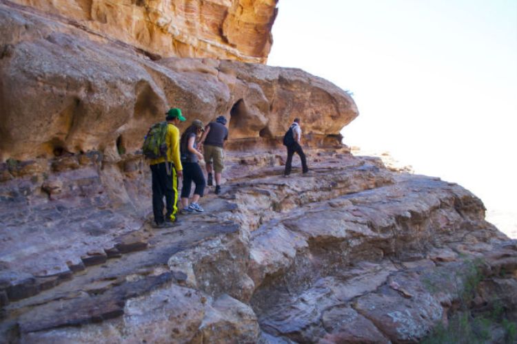 A trail skirts around a wall of rock
