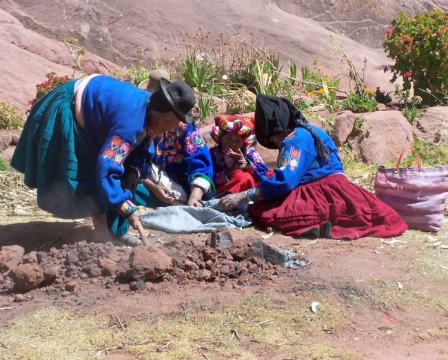 The Aymara women tended an underground oven, where plump rounded potatoes sizzled for our lunch. Photo by Carol L. Bowman