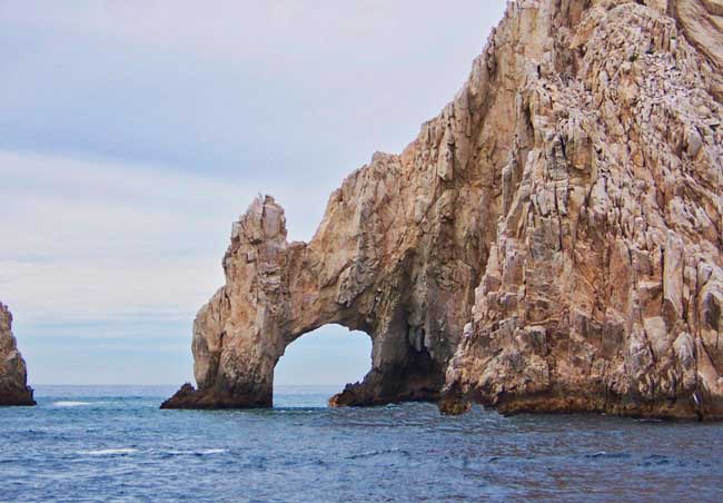 Massive granite rocks welcome cruise ships to Cabo San Lucas at the southern tip of the Baja Peninsula where the Pacific Ocean meets the Sea of Cortez. 