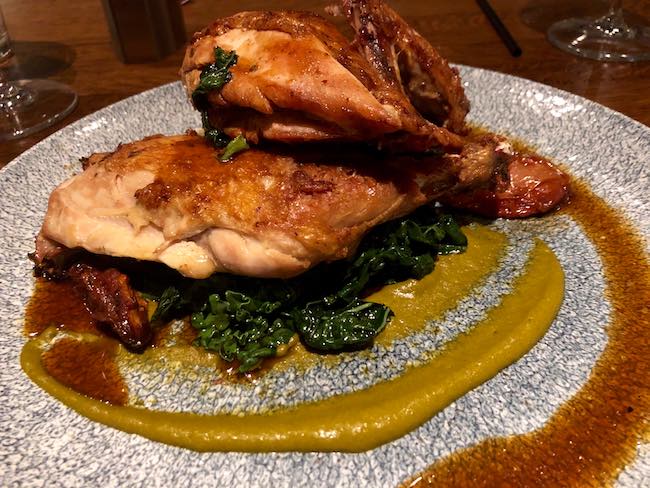 Half chicken on spinach and polenta. Photo by Claudia Carbone