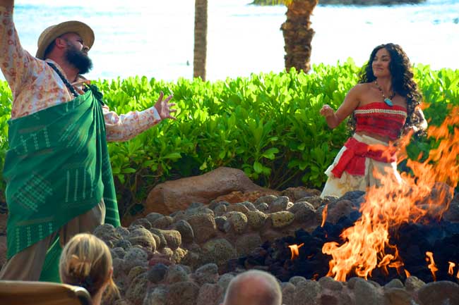 Uncle and Moana share island tales with guests around a campfire