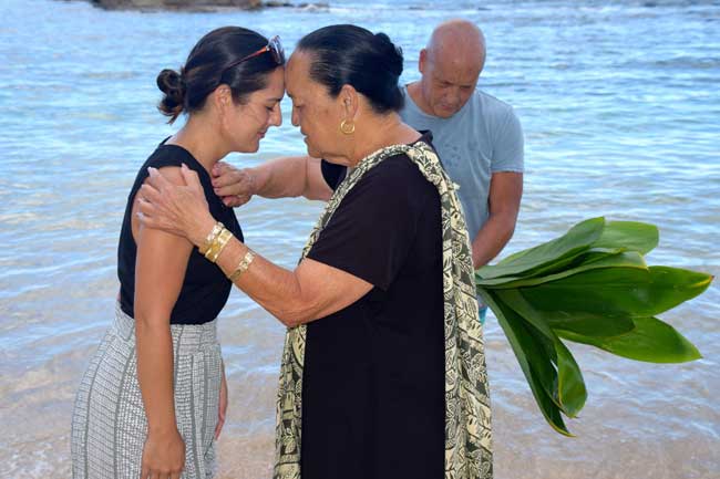 Kahu Auntie Nettie blesses a guest at Lanikuhonua Beach in front of the Four Seasons Resort.