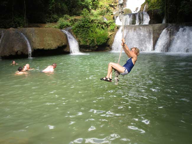 The author swinging into the waterfalls at YS Falls in Jamaica. Photo by Victor Block