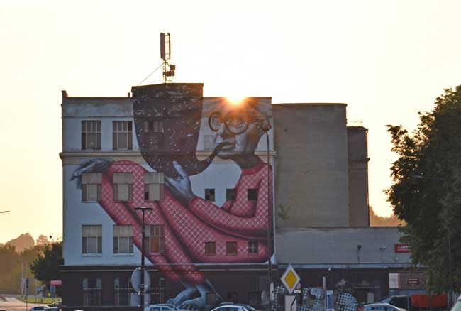 The old man with red trousers and glasses painted with a huge pipe on the wall near Kaunas castle.