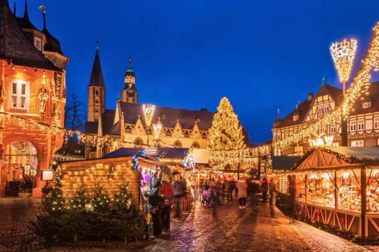 The traditional Christmas Market on the historic Market Square of Goslar, Germany at dusk. Photo by Juergen Sack from Getty Images Signature via Canva