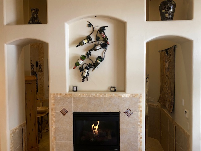 Fireplace wall opposite the bed. Photo by Claudia Carbone