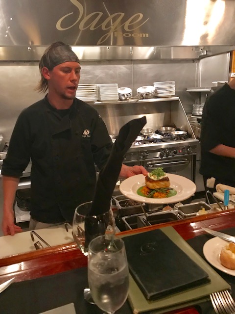 Chef presenting meal from open kitchen at Sage Room in Hilton Head