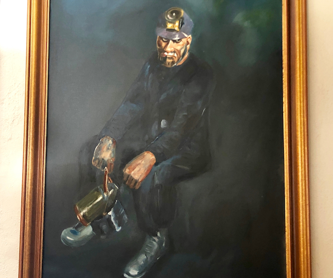 This painting in the living room depicts a miner and his weary plight. Photo by Claudia Carbone