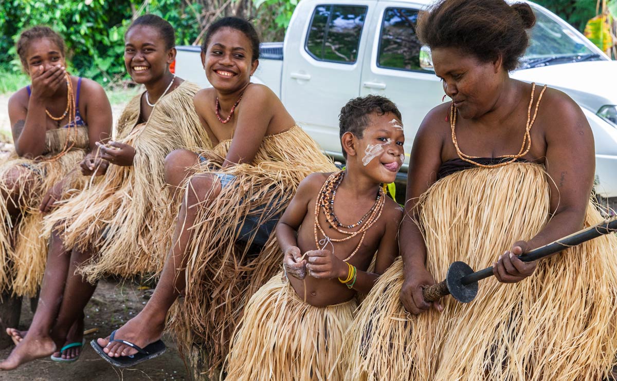 A Langalanga family, from Malaita Island, Ester, Margaret, Julie, and two siblings are members of the group who continue to make and use shell money, relax after demonstrating the process for visitors. Seen here in Mbokana Village, in Honiara, they come to the capital to sell shell money necklaces, and the ten-foot shell chains they use as barter and as a bride price. ©Steve Haggerty