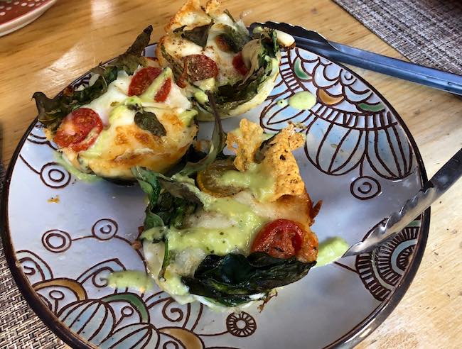 Baked eggs with pepper jack and cheddar cheese, baby spinach in a hash brown crust topped with paprika and a guacamole drizzle. Photo by Claudia Carbone