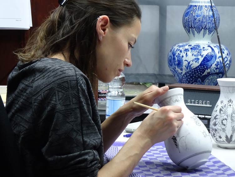 An artist paints a vase at Royal Delft. Photo by Janna Graber