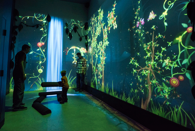 A family enjoying the unique โFunky Forrestโ exhibit at the Fort Collins Museum of Discovery. Photo by Richard Haro.