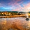 Old Faithful's steamy basin showcases nature's raw power, while the historic Old Faithful Inn behind it offers a warm reminder of Yellowstone's century-long tradition of welcoming adventurers to witness the spectacle. Photo by benedek from Getty Images Signature via Canva