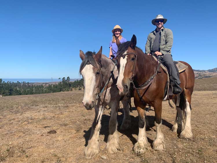 The author and her husband riding at Covell's Clydesdales in Cambria, California