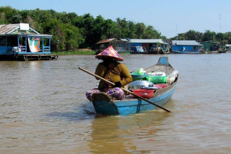 An old woman paddled her dug-out canoe restaurant, filled with steaming rice and fried fish, offering &lsquo;to-go&rsquo; dishes to the floating villagers