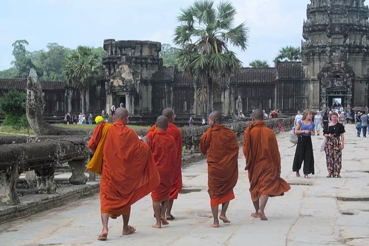 An orange string of Buddhist monks, wrapped in their saffron cloths, sprinted on their pilgrimage to the temple