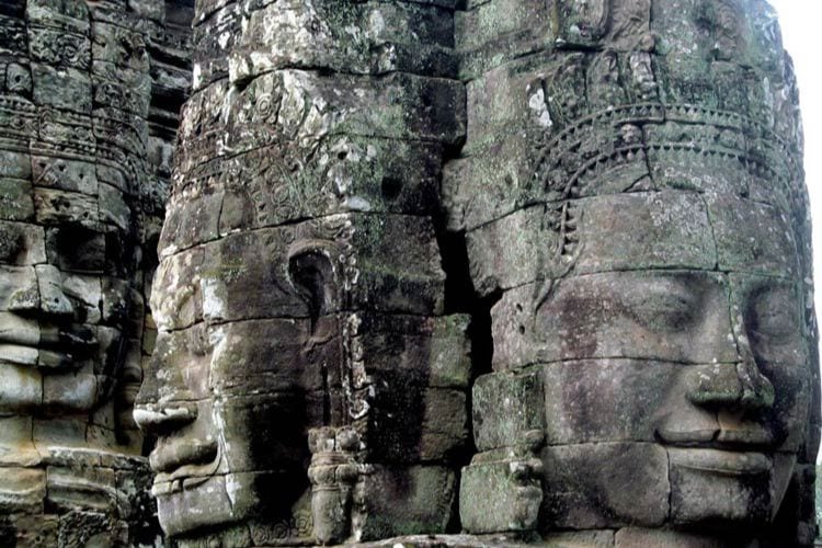Three-meter faces carved on all four sides of 54 stone towers of Banyon Temple, emerged through the jungle at Angkor Thom