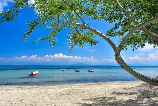 Boats float along the shore in Corfu Island, Greece