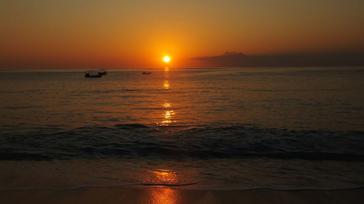 The sun setting over the Turks and Caicos Islands and boats also enjoy the view.