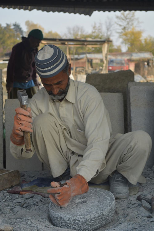 Mohammad Shabaan in the stone carving process of making millstones. 