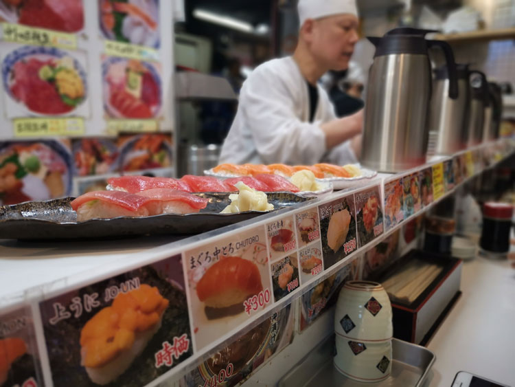 A chef talking to customers at one of the restaurants in Tsukji Market in Tokyo. 