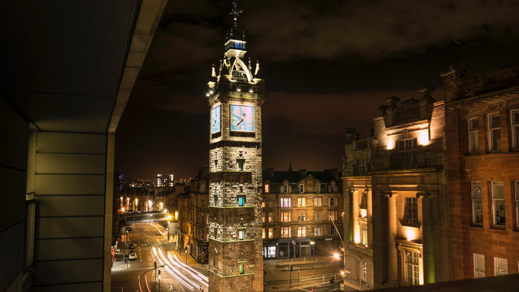 Tolbooth clock tower shining as bright as the city of Glasgow in the evening.