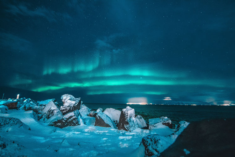 Stunning northern lights glow through the night along the coasts of Iceland.