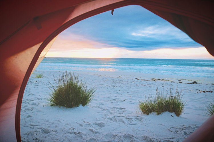 The sunrise over the ocean caught from a beachside campsite.