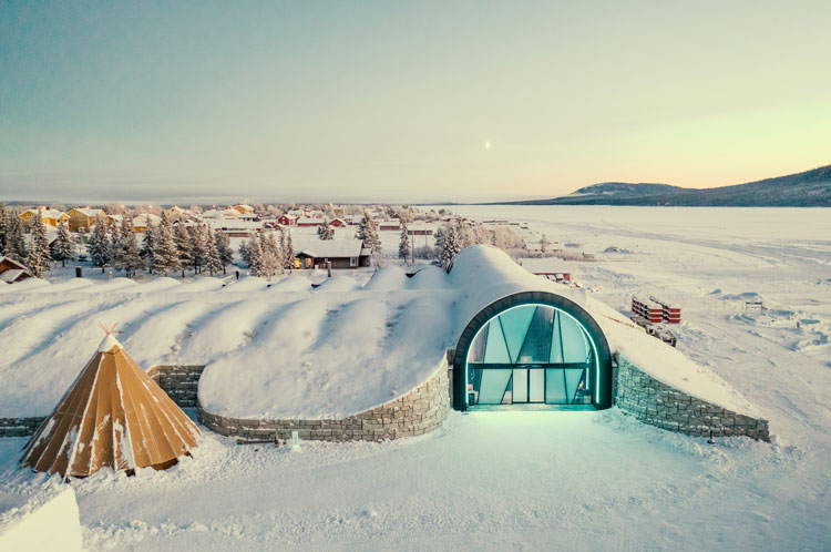 The Icehotel glowing under a blanket of snow.