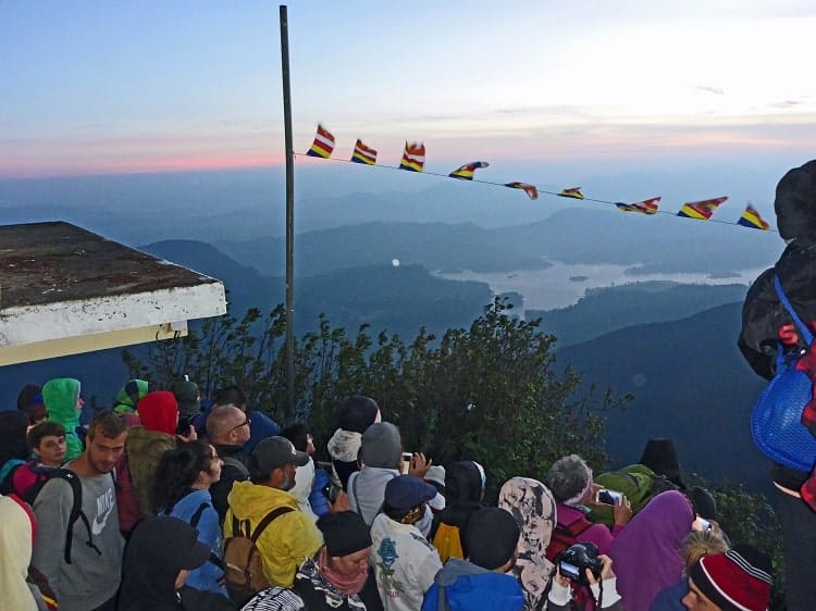 Pilgrims and hikers with cameras ready as the sun begins to rise on the summit.